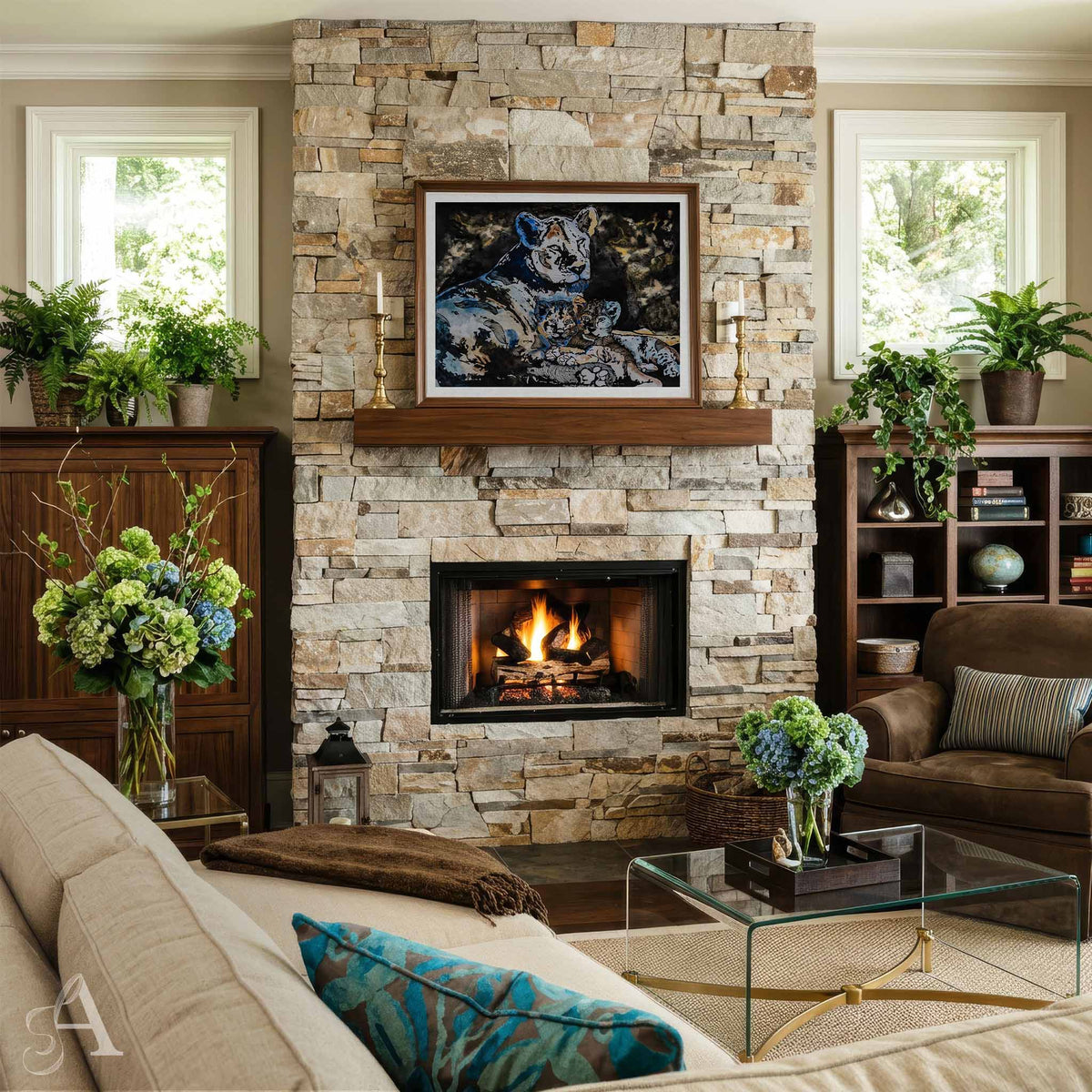 A framed artwork depicting a lion and her cubs is displayed on a stone fireplace mantel in a beautifully styled living room with a stone fireplace, sofa, and potted plants.
