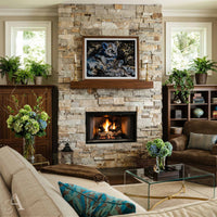 A framed artwork depicting a lion and her cubs is displayed on a stone fireplace mantel in a beautifully styled living room with a stone fireplace, sofa, and potted plants.