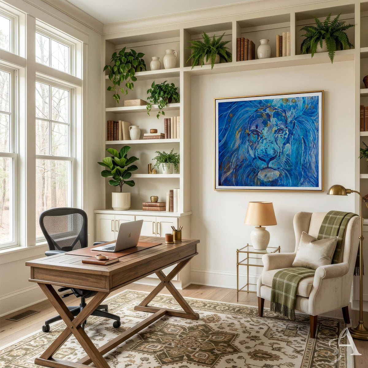 A bright home office with a wooden desk, black mesh office chair, beige armchair with a green plaid throw, built-in white shelves with plants and books, and a large framed blue lion painting on the wall.